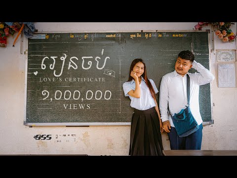 Khmer singers All3rgy and Chan Sreykhouch posing in school outfits beside a chalkboard with “Love’s Certificate” written on it