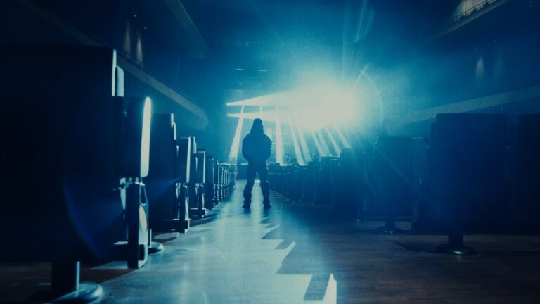 VannDa standing in a blue cinematic theater setting for Neon Light music video